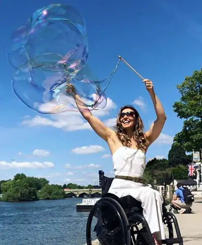 Samanta Bullock blowing bubbles by a lake in London