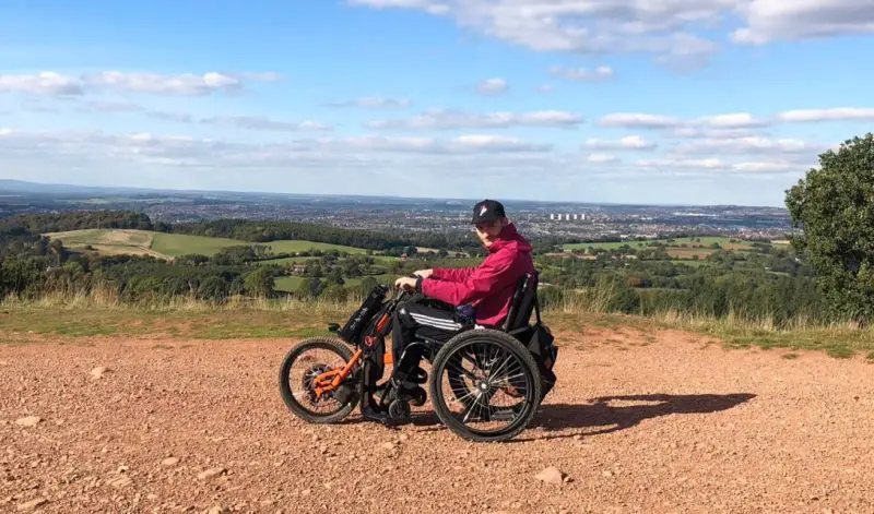 Dan in a wheelchair trike on a hilltop