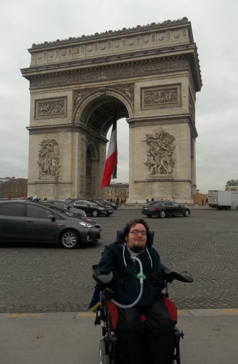 Wheelchair user Derry Felton in front of the Arc de Triomph