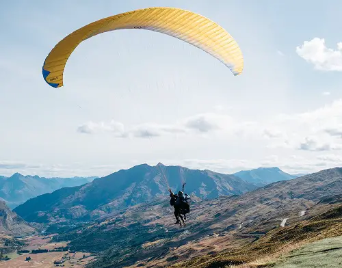 Two people gliding over mountains