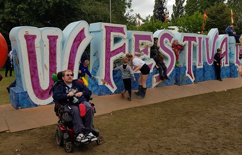 Alex Squires at Isle of Wight festival in front of a festival sign