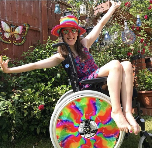 Rebecca Sullivan with rainbow wheels on her wheelchair