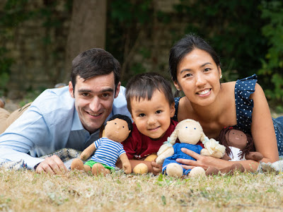 Rafael Tselikas, son Alex and Winnie Mak smile at camera holding three soft toys