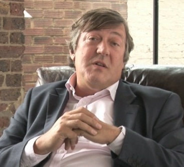 Stephen Fry sat in an armchair talking