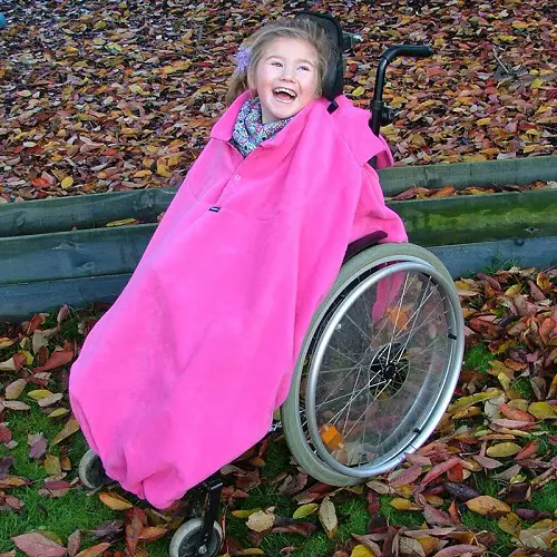 Young disabled girl in fuschia fleece wheelchair cover