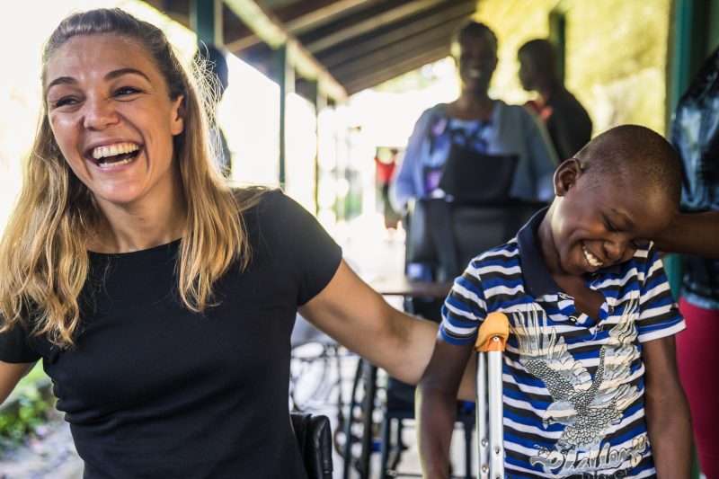 Sophie Morgan laughing with a young disabled child in Africa