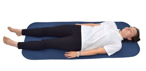 A person lying flat on their back on the adult changing mat
