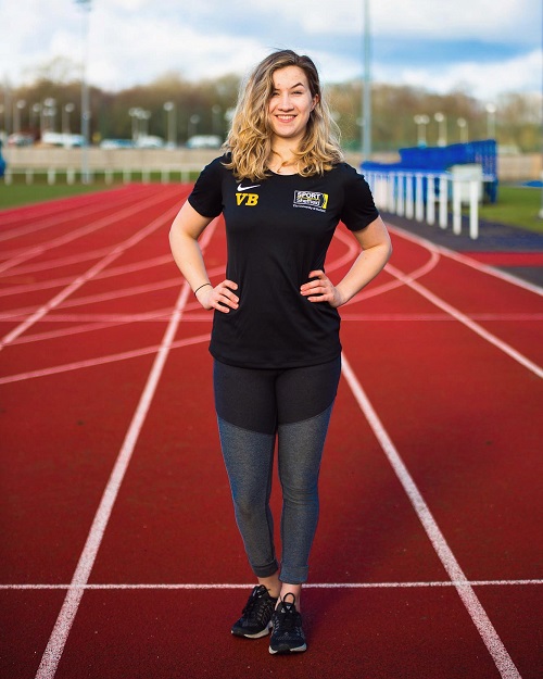 Victoria Baskett standing on a running track in a black T-shirt and leggings