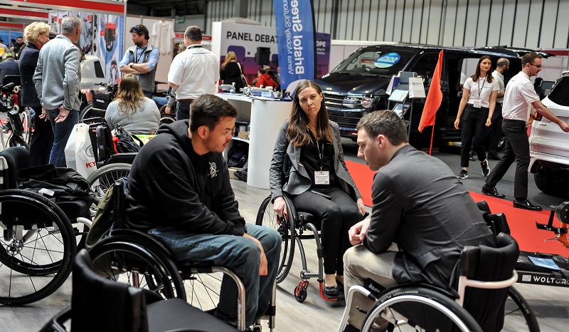 A wheelchair user talking to a manufacturer at Naidex