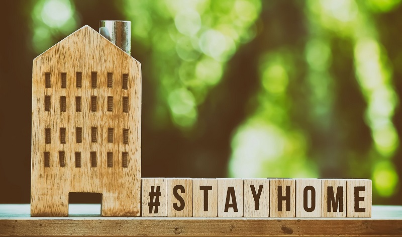 House cut out of wood and wooden blocks spelling out stay home