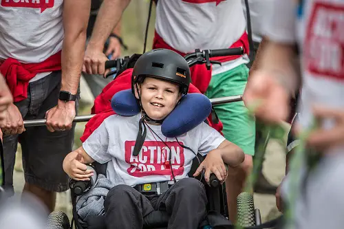 Zach smiling while climbing Mount Snowdon in a Mountain Trike all-terrain wheelchair