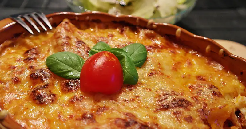 Lasagne in a round bowl with a tomato on top