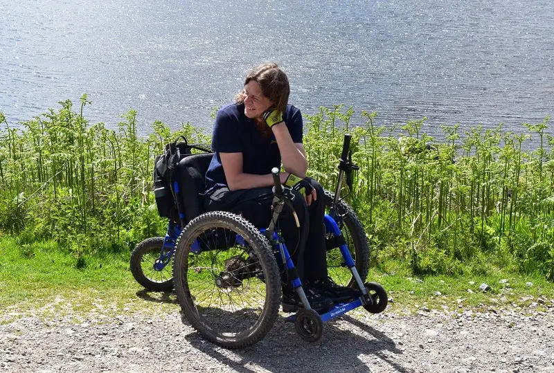 Craig Grimes in his all-terrain wheelchair on an uneven path next to a lake