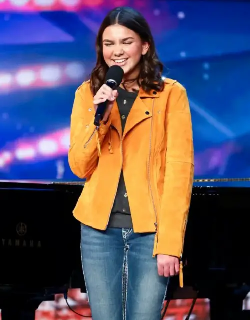 Sirine Jahangir standing on the Britain's Got Talent stage holding a microphone