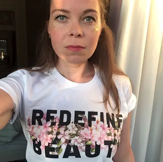 Juliette Burton wearing a white T-shirt with pink flowers and the words redefining beauty
