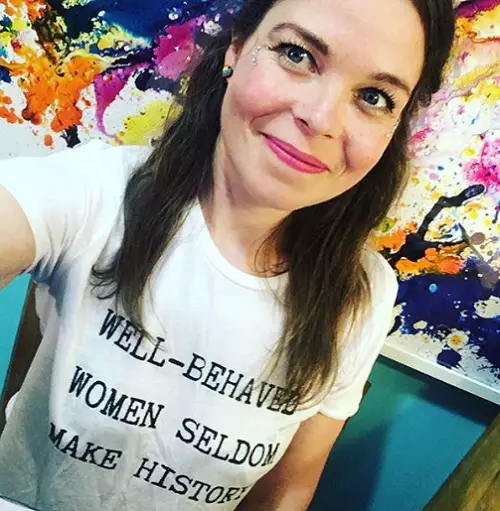 Juliette Burton wearing a white T-shirt with the words well-behaved women seldom make history