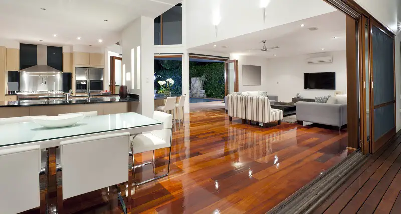 Large open-plan kitchen, dining room and living room with white futnirue and wooden flooring
