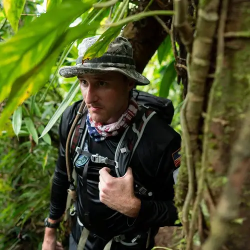 Keith Knoop in the jungle with a backpack and hat on