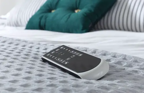 Handset for an adjustable bed lying on top of one