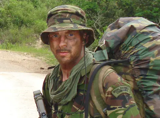 JJ Chalmers dressed in camouflage gear with a large rucksack on his back