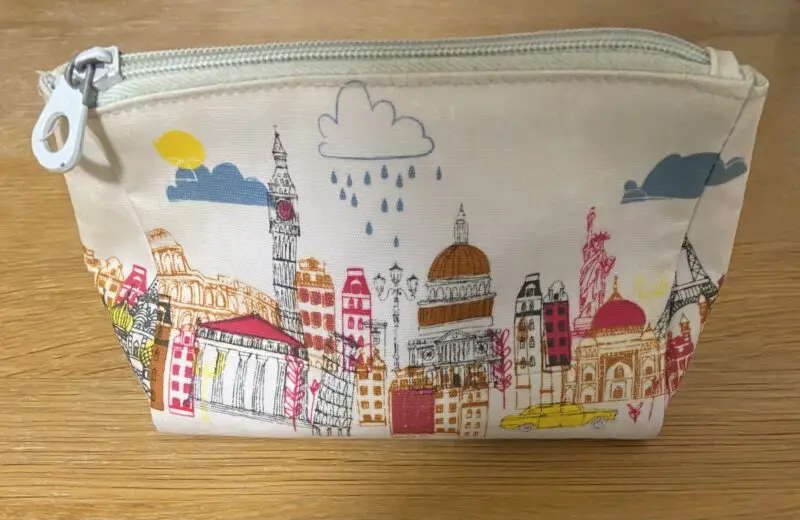 White cosmetic bag with colourful silhouette of London in pinks, yellows and orange