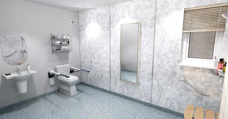 Accessible bathroom in an adapted modular home extension with grey floor and wall tiles, a toilet with supports, walk-in shower and shower chair 