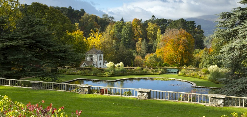 Bodnant wheelchair-accessible gardens in Wales showing formal gardens with a large pond looking out over woodland