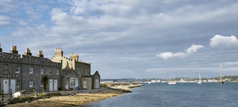 Wheelchair accessible Brownsea Island with a row of stone houses on the shore with the sea in front