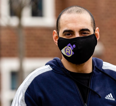 Close up of Paralympian Ali Jawad wearing a blue hoodie and face mask