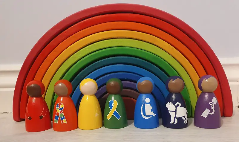 Busy Life Peg Dolls stood in front of a rainbow