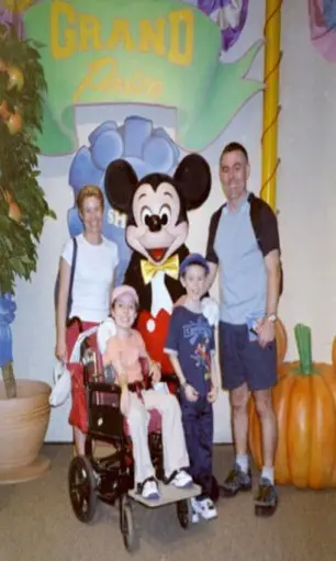 Emma in her wheelchair with her family in Disney World Florida