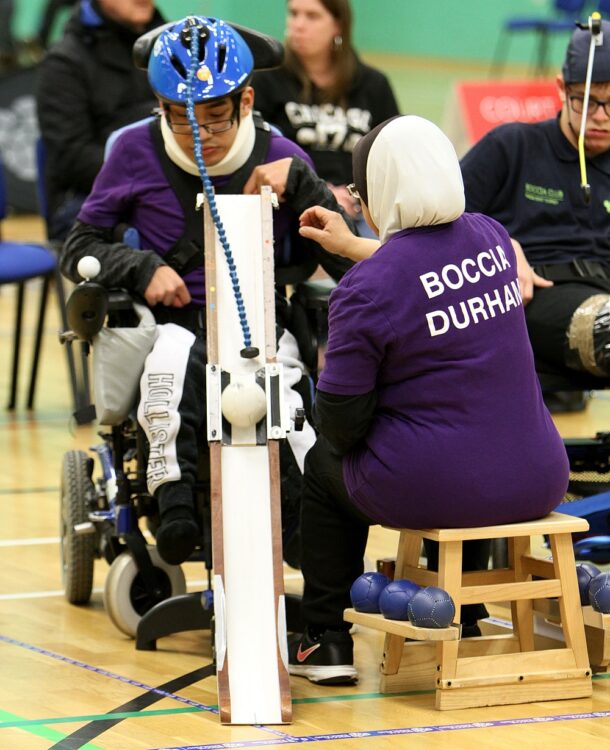 A girl in a wheelchair playing Boccia using a ramp