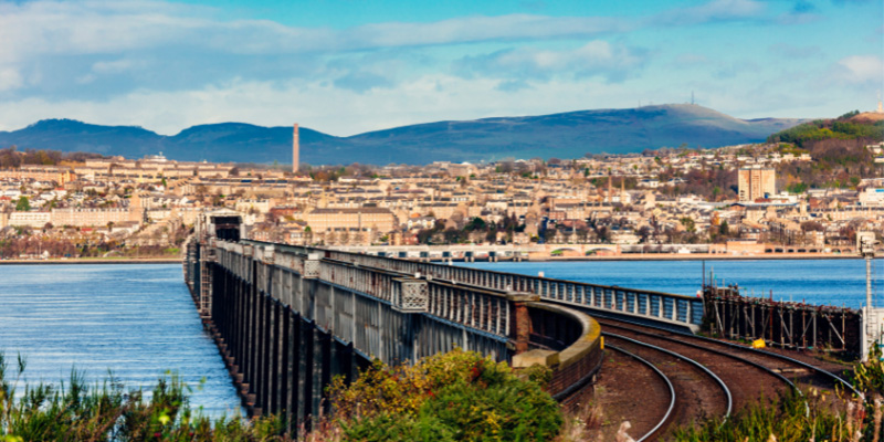 The city of Dundee, Scotland, with mountains behind the city viewed from the Tay Rail Bridge crossing a rive